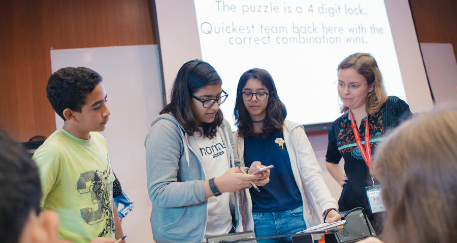High school students learn problem solving from Giselle Reis, assistant professor of computer science