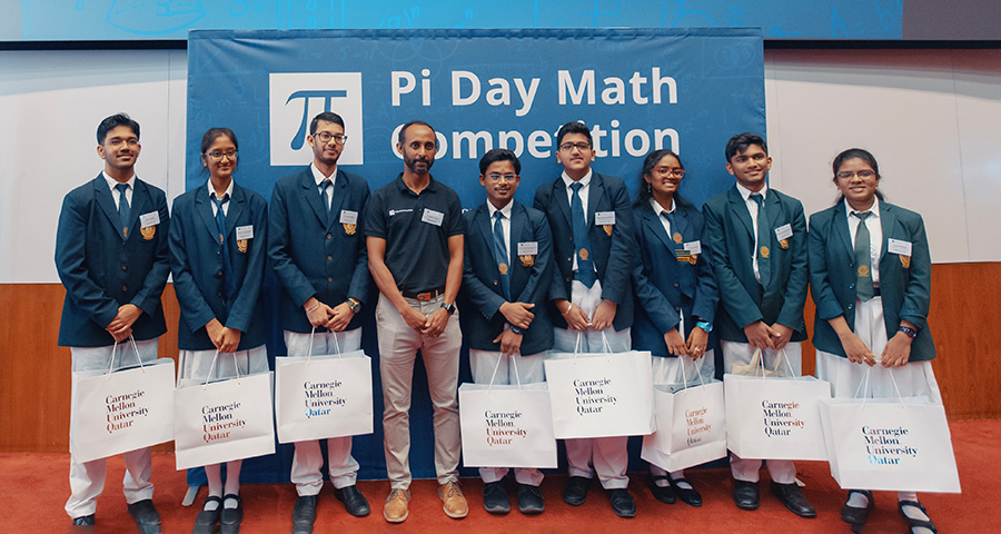 CMU-Q's Zelealem Yilma, associate teaching professor of mathematics, with the top two teams from DPS Modern Indian School.