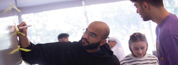Students engaged in front of the whiteboard.